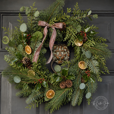 Countryside Simplicity Christmas Wreath - Bring timeless countryside charm to your front door with our countryside simplicity Christmas Wreath handmade in the studio by Finishing Touch — a full, generously sized creation handcrafted from lush evergreen foliage. Layers Nordmann fir,and silvery eucalyptus give it a rich, natural depth, while clusters of deep red berries, earthy pinecones, and delicate slices of dried citrus add warmth and texture throughout.

Finished with a soft velvet bow that trails elegantly down the ring, this wreath strikes the perfect balance between rustic and refined. It's an effortless way to welcome the season — and your guests — with a touch of heirloom style.